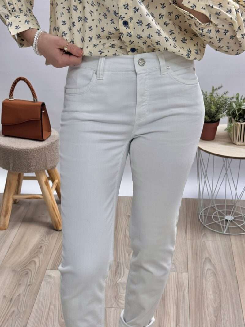 jean blanc femme anna montana coupe ajustée, porté avec une blouse imprimée beige et des sandales compensées.