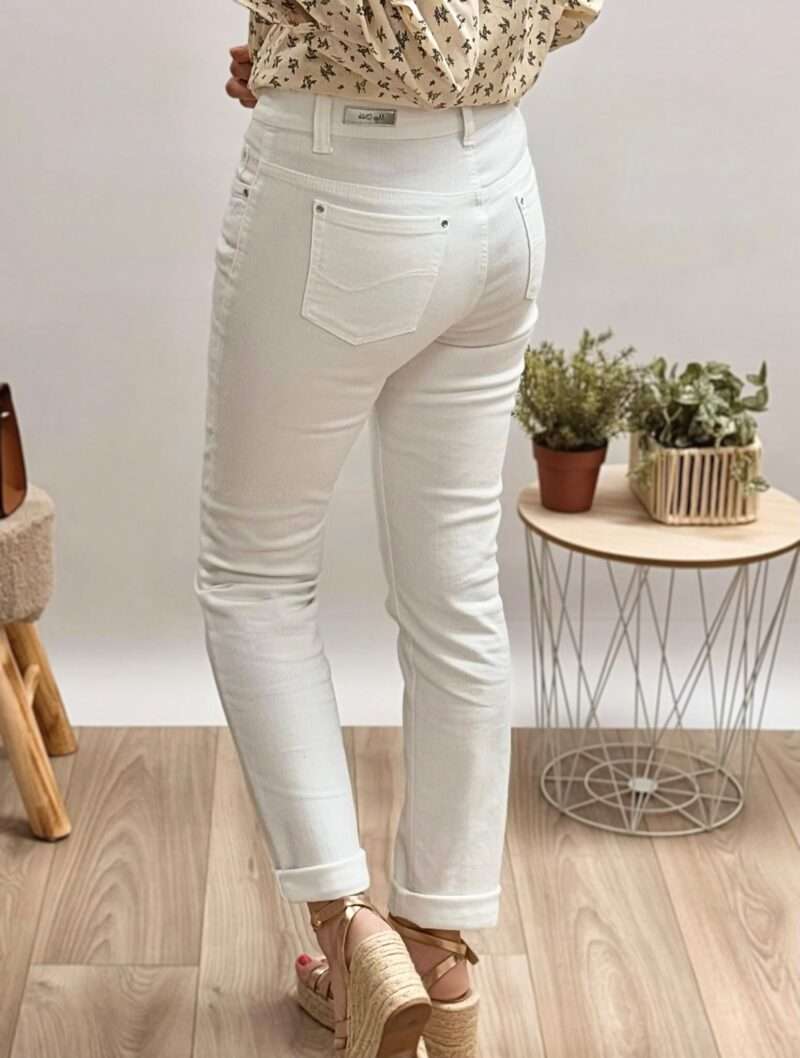 : jeans blanc femme anna montana coupe ajustée, porté avec une blouse imprimée beige et des sandales compensées.