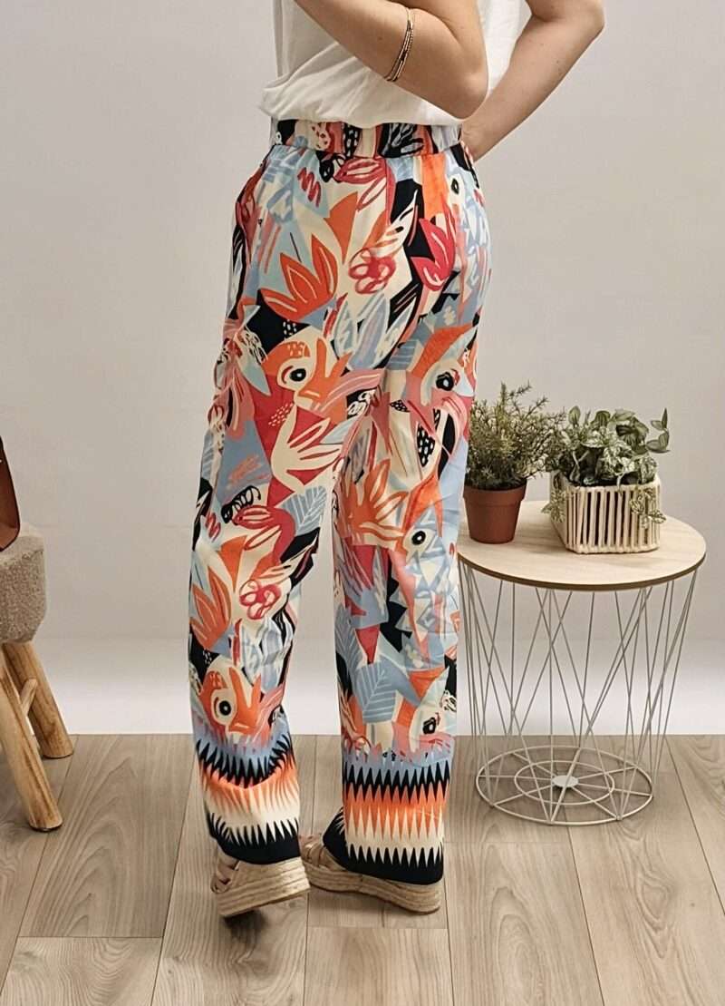 pantalon fluide femme anna montana avec imprimé floral et géométrique coloré, porté avec un t-shirt blanc et des sandales compensées