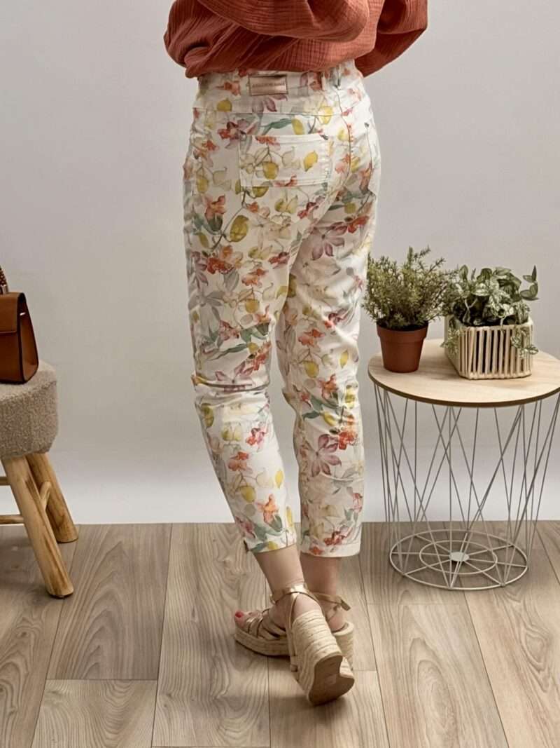 pantalon imprimé fleuri anna montana, coupe droite, porté avec une blouse en gaze de coton rouge et des sandales compensées.