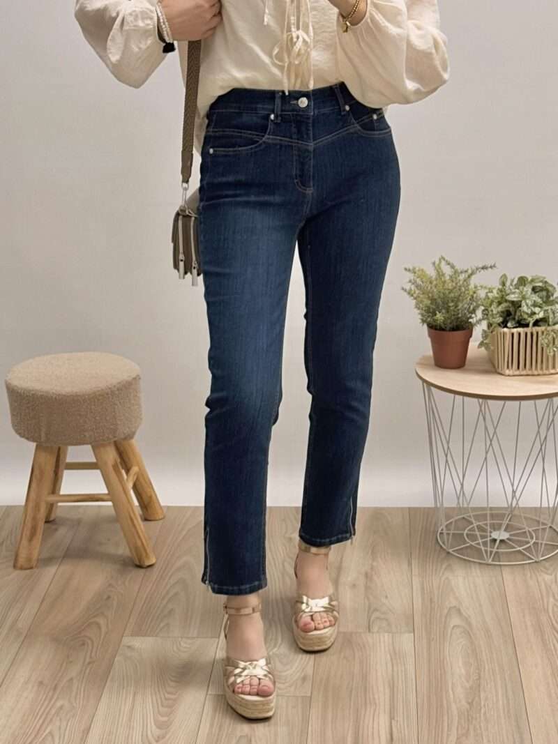 jeans bleu foncé coupe slim anna montana angelika, porté avec un chemisier beige à manches bouffantes et des sandales compensées.