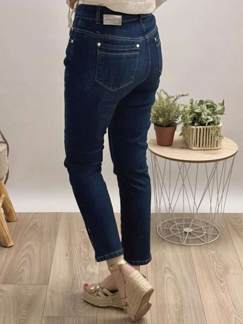 jeans bleu foncé coupe slim anna montana angelika, porté avec un chemisier beige à manches bouffantes et des sandales compensées.