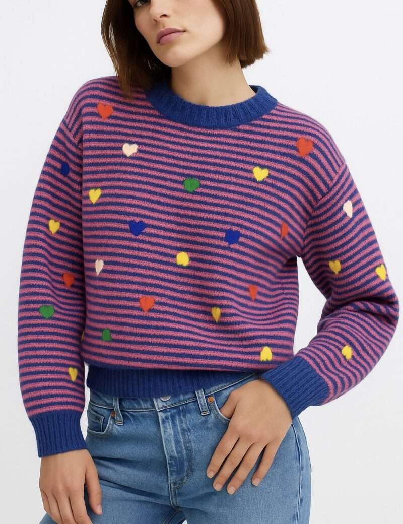 Pull tendance en maille rose et bleu à rayures avec cœurs multicolores porté avec jean