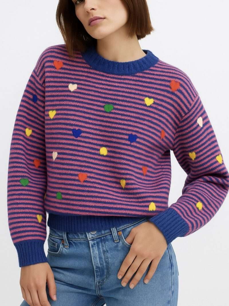 Pull tendance en maille rose et bleu à rayures avec cœurs multicolores porté avec jean