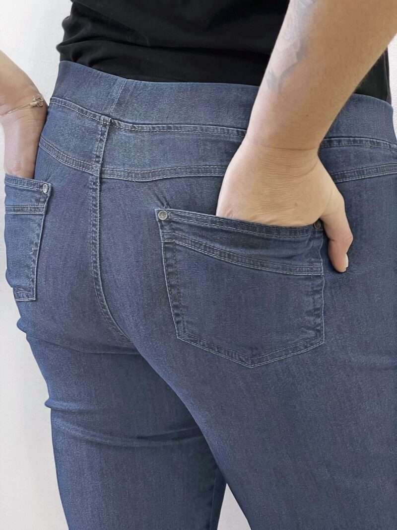 Découvrez le jean Anna Montana Angelika Jump In Slim Fit, le modèle plébiscité qui redéfinit le confort. Il possède l'apparence authentique d'un jean classique en denim bleu foncée, mais offre la souplesse et l'aisance d'un pantalon de détente. Il est parfaitement pensé pour les femmes de 50 ans et plus qui recherchent un jean à la fois moderne et d'un confort absolu au quotidien. Pourquoi l'Angelika Jump In est l'incontournable de votre dressing : L'Effet "Jump In" : La Révolution du Confort C'est l'innovation qui change tout : ce jean s'enfile sans effort grâce à sa conception "pull-on". Pas de fermeture éclair, pas de bouton à l'avant ! Il suffit de l'enfiler pour se sentir immédiatement à l'aise. (Voir photos, la taille est lisse et large). La Ceinture "Magic" : Ventre Plat et Maintien Doux La taille est équipée d'une large ceinture élastiquée plate et invisible qui épouse votre ventre sans comprimer ni marquer. Elle procure un maintien parfait et un subtil effet ventre plat, garantissant un bien-être durable toute la journée, même assise. Denim Stretch et Silhouette Slim Fit Confectionné dans un denim stretch de haute qualité, ce jean est incroyablement souple. Il suit tous vos mouvements tout en conservant la coupe Slim Fit (ajustée sans être moulante). Cette coupe flatteuse affine la jambe et assure une silhouette moderne sans sacrifier l'aisance. Détails Authentiques Malgré l'absence de zip, les détails caractéristiques d'un jean sont présents : fausses poches cavalières sur le devant (pour une silhouette lissée) et poches plaquées fonctionnelles à l'arrière (voir photos), avec surpiqûres et rivets discrets. Le denim bleu foncée (brut/foncé) est idéal pour un look chic et polyvalent. Entdecken Sie die Anna Montana Jeans Angelika Jump In Slim Fit, das gefeierte Modell, das Komfort neu definiert. Sie bietet das authentische Aussehen einer klassischen Jeans aus dunkelblauem Denim, jedoch die Weichheit und Bequemlichkeit einer Freizeithose. Sie ist perfekt konzipiert für Frauen ab 50 Jahren, die eine Jeans suchen, die sowohl modern als auch im Alltag absolut bequem ist. Warum die Angelika Jump In ein Garderoben-Highlight ist: Der "Jump In"-Effekt: Die Revolution des Tragekomforts Diese Innovation ändert alles: Diese Jeans lässt sich dank ihres "Pull-on"-Designs mühelos anziehen. Kein Reißverschluss, kein Knopf vorne! Einfach reinschlüpfen und sich sofort wohlfühlen. (Siehe Fotos, der Bund ist glatt und breit.) Der "Magic"-Bund: Flacher Bauch und Sanfter Halt Der Bund ist mit einem breiten, flachen und unsichtbaren Gummizug ausgestattet, der sich perfekt an den Bauch anschmiegt, ohne einzuengen oder Abdrücke zu hinterlassen. Er sorgt für einen idealen Halt und einen dezenten Flacher-Bauch-Effekt, der den ganzen Tag über anhält, auch im Sitzen. Stretch-Denim und Slim Fit Silhouette Hergestellt aus hochwertigem Stretch-Denim, ist diese Jeans unglaublich geschmeidig. Sie macht jede Bewegung mit und behält dabei den Slim Fit Schnitt (figurbetont, aber nicht hauteng). Dieser schmeichelhafte Schnitt streckt das Bein und sorgt für eine moderne Silhouette, ohne auf Bequemlichkeit zu verzichten. Authentische Details Trotz des fehlenden Reißverschlusses sind die typischen Jeans-Details vorhanden: angedeutete Taschen vorne (für eine glattere Silhouette) und funktionale aufgesetzte Taschen hinten (siehe Fotos), mit dezenten Nähten und Nieten. Das dunkelblaue Denim (Raw/Dunkel) ist ideal für einen schicken und vielseitigen Look.