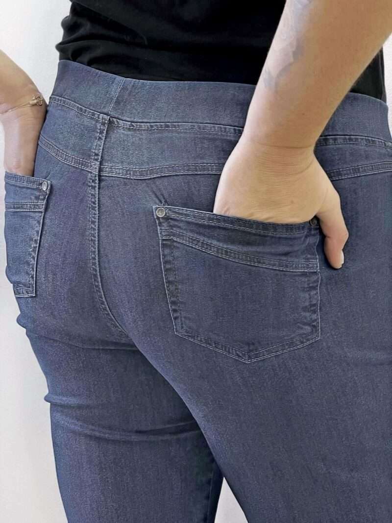 Découvrez le jean Anna Montana Angelika Jump In Slim Fit, le modèle plébiscité qui redéfinit le confort. Il possède l'apparence authentique d'un jean classique en denim bleu foncée, mais offre la souplesse et l'aisance d'un pantalon de détente. Il est parfaitement pensé pour les femmes de 50 ans et plus qui recherchent un jean à la fois moderne et d'un confort absolu au quotidien. Pourquoi l'Angelika Jump In est l'incontournable de votre dressing : L'Effet "Jump In" : La Révolution du Confort C'est l'innovation qui change tout : ce jean s'enfile sans effort grâce à sa conception "pull-on". Pas de fermeture éclair, pas de bouton à l'avant ! Il suffit de l'enfiler pour se sentir immédiatement à l'aise. (Voir photos, la taille est lisse et large). La Ceinture "Magic" : Ventre Plat et Maintien Doux La taille est équipée d'une large ceinture élastiquée plate et invisible qui épouse votre ventre sans comprimer ni marquer. Elle procure un maintien parfait et un subtil effet ventre plat, garantissant un bien-être durable toute la journée, même assise. Denim Stretch et Silhouette Slim Fit Confectionné dans un denim stretch de haute qualité, ce jean est incroyablement souple. Il suit tous vos mouvements tout en conservant la coupe Slim Fit (ajustée sans être moulante). Cette coupe flatteuse affine la jambe et assure une silhouette moderne sans sacrifier l'aisance. Détails Authentiques Malgré l'absence de zip, les détails caractéristiques d'un jean sont présents : fausses poches cavalières sur le devant (pour une silhouette lissée) et poches plaquées fonctionnelles à l'arrière (voir photos), avec surpiqûres et rivets discrets. Le denim bleu foncée (brut/foncé) est idéal pour un look chic et polyvalent. Entdecken Sie die Anna Montana Jeans Angelika Jump In Slim Fit, das gefeierte Modell, das Komfort neu definiert. Sie bietet das authentische Aussehen einer klassischen Jeans aus dunkelblauem Denim, jedoch die Weichheit und Bequemlichkeit einer Freizeithose. Sie ist perfekt konzipiert für Frauen ab 50 Jahren, die eine Jeans suchen, die sowohl modern als auch im Alltag absolut bequem ist. Warum die Angelika Jump In ein Garderoben-Highlight ist: Der "Jump In"-Effekt: Die Revolution des Tragekomforts Diese Innovation ändert alles: Diese Jeans lässt sich dank ihres "Pull-on"-Designs mühelos anziehen. Kein Reißverschluss, kein Knopf vorne! Einfach reinschlüpfen und sich sofort wohlfühlen. (Siehe Fotos, der Bund ist glatt und breit.) Der "Magic"-Bund: Flacher Bauch und Sanfter Halt Der Bund ist mit einem breiten, flachen und unsichtbaren Gummizug ausgestattet, der sich perfekt an den Bauch anschmiegt, ohne einzuengen oder Abdrücke zu hinterlassen. Er sorgt für einen idealen Halt und einen dezenten Flacher-Bauch-Effekt, der den ganzen Tag über anhält, auch im Sitzen. Stretch-Denim und Slim Fit Silhouette Hergestellt aus hochwertigem Stretch-Denim, ist diese Jeans unglaublich geschmeidig. Sie macht jede Bewegung mit und behält dabei den Slim Fit Schnitt (figurbetont, aber nicht hauteng). Dieser schmeichelhafte Schnitt streckt das Bein und sorgt für eine moderne Silhouette, ohne auf Bequemlichkeit zu verzichten. Authentische Details Trotz des fehlenden Reißverschlusses sind die typischen Jeans-Details vorhanden: angedeutete Taschen vorne (für eine glattere Silhouette) und funktionale aufgesetzte Taschen hinten (siehe Fotos), mit dezenten Nähten und Nieten. Das dunkelblaue Denim (Raw/Dunkel) ist ideal für einen schicken und vielseitigen Look.